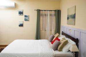 a bedroom with a bed with white sheets and pillows at Hotel le Pelican in Lomé