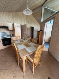 a kitchen with a wooden dining table and chairs at Feriendorf Klosterheide in Lindow