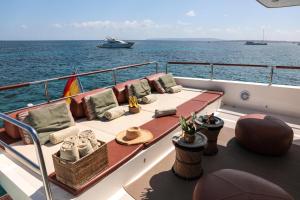 a boat with chairs and a table on the water at House of Hütter- Floating Home Goldfinger in Ibiza Town