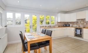 a kitchen with a wooden table and chairs at Large detached Cambridgeshire Countryside Home in Wilburton