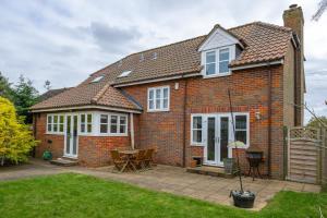 a red brick house with a table and chairs at Large detached Cambridgeshire Countryside Home in Wilburton