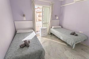 two beds in a room with two teddy bears on them at Los Huertos de Nerja 6 in Nerja