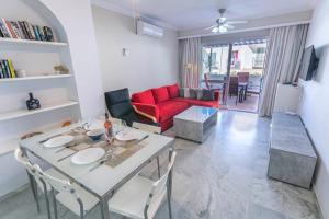 salon ze stołem i czerwoną kanapą w obiekcie Canovas Nerja - Casa adosada con piscina Los Huertos 6 w mieście Nerja