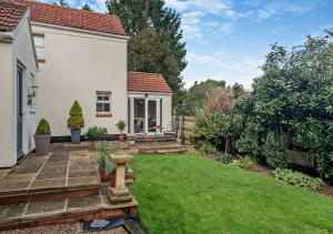 un cortile di una casa con giardino di Willow Cottage - Corpusty a Briston