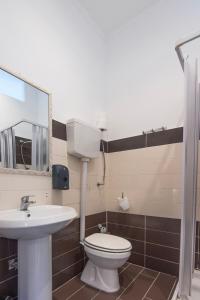 une salle de bains avec toilettes, lavabo et miroir dans l'établissement Casa Vacanze Carolina 348, à Naples