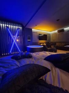 a bedroom with a large bed with a blue lighting at Love Room in Strasbourg +7 photos