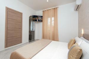 una camera con letto bianco e TV a schermo piatto di Casa Vacanze Carolina 348 a Napoli