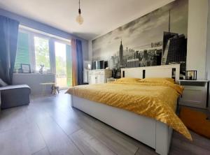 a bedroom with a large bed with a yellow bedspread at Cozy apartment with balcony 10 min from the beach in Rijeka