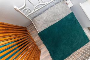 un tapis vert sur le sol à côté d'un lit dans l'établissement Seaside Apartments - Jūros apartamentai, à Klaipėda 23 autres photos