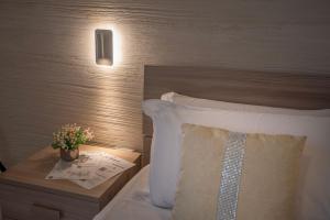 - une chambre dotée d'un lit avec un oreiller et d'une table avec une plante dans l'établissement Casa Vacanze Carolina 348, à Naples