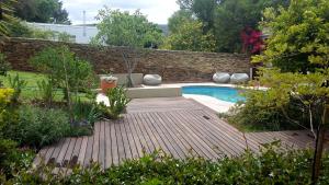 a garden with a wooden deck and a swimming pool at Villa Limonicella in Barrydale