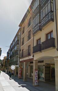 a tall building with balconies on a city street at Apartamentos "El collado Suites" Soria Centro in Soria