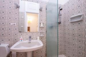 a bathroom with a sink and a mirror at Charming elegant home in Casalpalocco, Roma ***** in Casal Palocco