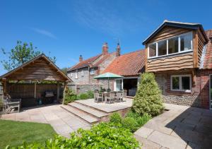 a backyard of a house with a patio at Boat Barn Cottage 6 in Blakeney