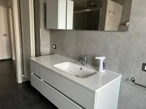 Masera的住宿－Casa Dolce Casa，浴室设有白色水槽和镜子