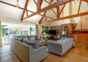 a living room with couches and a brick wall at Boat Barn Cottage 6 in Blakeney