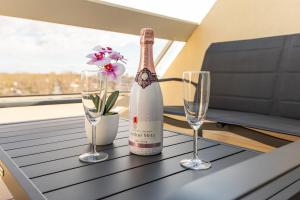 a bottle of wine and two glasses on a table at Héliopolis Naturist Luxury in Cap d'Agde