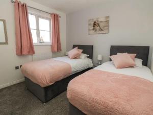 two beds sitting next to each other in a bedroom at THE Beach House in Prestatyn
