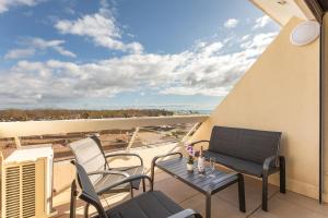a balcony with a table and chairs and a view at Héliopolis Naturist Luxury in Cap d'Agde