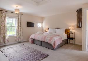 a bedroom with a large bed and a window at Valley House in Cley next the Sea