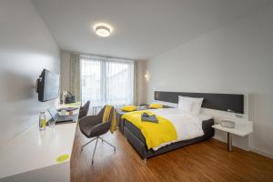 a bedroom with a yellow and white bed and a chair at Gästehaus am Schloss in Schwetzingen