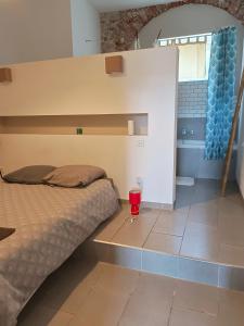 ein Schlafzimmer mit einem Bett und einem roten Glas auf dem Boden in der Unterkunft Quetzal in Perpignan