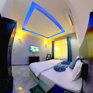 a bedroom with a large bed with a blue light at Velmont Hotel in Dar es Salaam