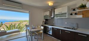 a kitchen with a table and a view of the ocean at Apartman Doris in Dramalj