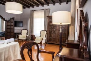 a bedroom with a bed and chairs and a lamp at RVHotels Palau Lo Mirador in Torroella de Montgrí