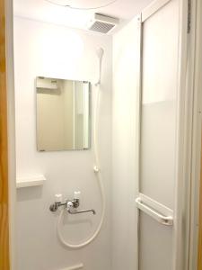 uma casa de banho com um chuveiro e um espelho. em Tokyo Art House em Tóquio