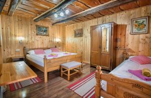 1 Schlafzimmer mit 2 Betten in einem Holzzimmer in der Unterkunft Holiday Home David in Slunj