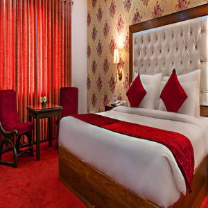 1 dormitorio con 1 cama grande y alfombra roja en Hotel De Huespedes near international airport en Nueva Delhi