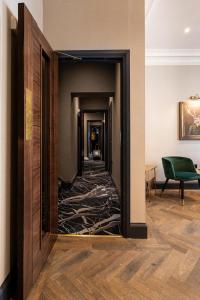 um corredor com um espelho num quarto de hotel em The House on Warwick em Londres