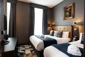 a hotel room with two beds and a window at The House on Warwick in London