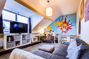 a living room with a couch and a tv at Entire artistic open-apartment in Southend-on-Sea