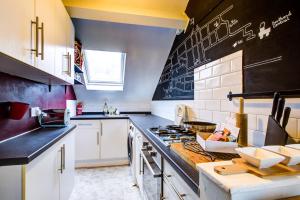 a kitchen with a stove and a blackboard on the wall at Entire artistic open-apartment in Southend-on-Sea