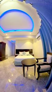 Velmont Hotel في دار السلام: غرفة نوم بسرير وطاولة وكرسي
