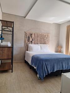 1 dormitorio con 1 cama grande con manta azul en Casatua Pousada, en Juquei