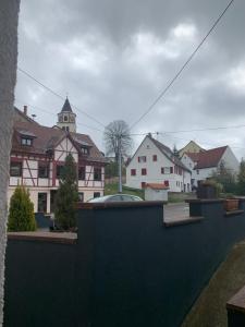 a view of a town with houses and a church at Pension zur Sonnenalb in Sonnenbühl