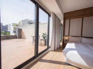 ein Schlafzimmer mit einem Bett und einem großen Fenster in der Unterkunft Hôtel de Ľeau in Anping