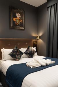 a bed with a blue blanket and pillows on it at The House on Warwick in London