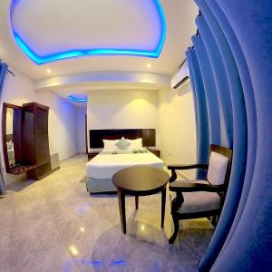 1 dormitorio con 1 cama, 1 mesa y 1 silla en Velmont Hotel en Dar es Salaam