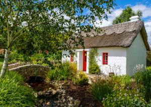 a cottage in the garden with red shutters at The Villa Rose Hotel & V-Spa in Ballybofey