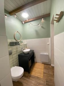 ein Badezimmer mit einem WC, einem Waschbecken und einem Spiegel in der Unterkunft B&B by Mo in Etyek