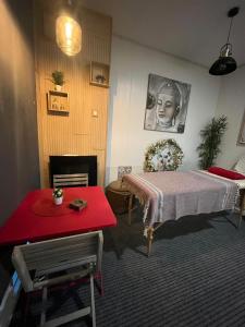1 dormitorio con cama y mesa roja en Apart Lamas Luxo en Paços de Brandão