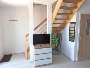 a loft bed with a tv in a room at MILAN Domki Mielno in Mielno