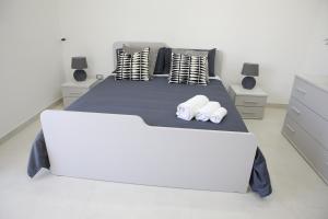 - une chambre blanche avec un grand lit blanc et des oreillers dans l'établissement Scavi di Pompei - Intero appartamento max 6 persone - Pompeii Getaway, à Scafati