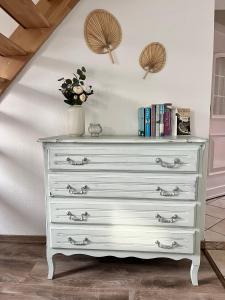 a white dresser with a vase on top of it at FeWo Wisch in Nordenham +4 photos