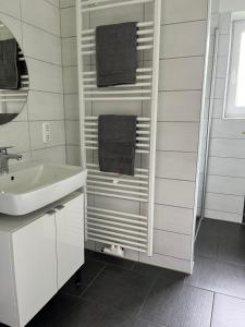 a white bathroom with a sink and a mirror at FeWo Wisch in Nordenham