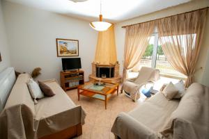 uma sala de estar com dois sofás e uma lareira em House Stella em Keramoti